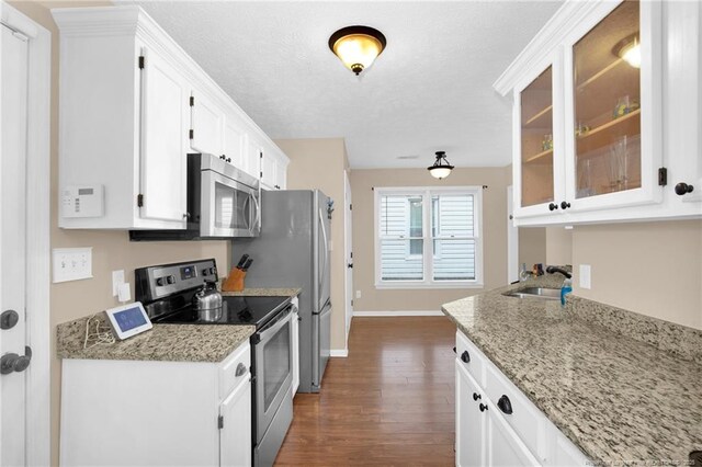 5921 Bloomsbury Dr, Fayetteville, NC 28306 - kitchen with appliances with stainless steel finishes, a sink, dark wood-style floors, white cabinetry, and baseboards