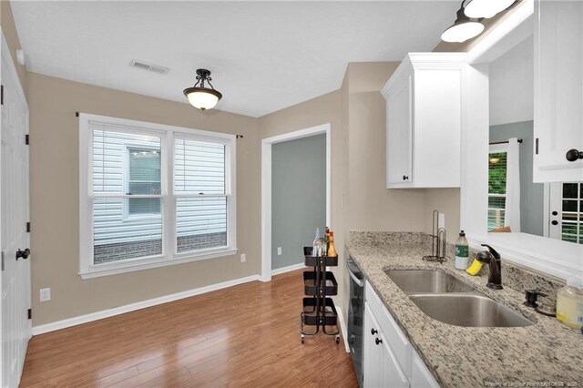 5921 Bloomsbury Dr, Fayetteville, NC 28306 - kitchen featuring a sink, wood finished floors, baseboards, and white cabinetry