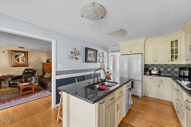 5924 Finish Line Dr, Hope Mills, NC 28348 - kitchen with cream cabinetry, a sink, appliances with stainless steel finishes, light wood-type flooring, and ornamental molding