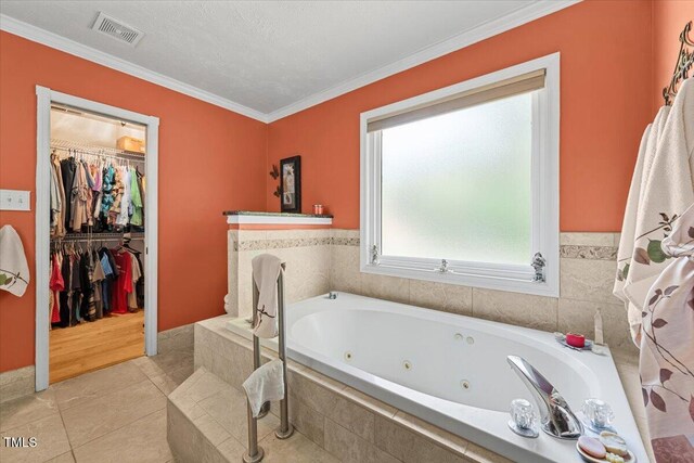 5924 Finish Line Dr, Hope Mills, NC 28348 - full bathroom featuring a jetted tub, ornamental molding, tile patterned floors, and a spacious closet