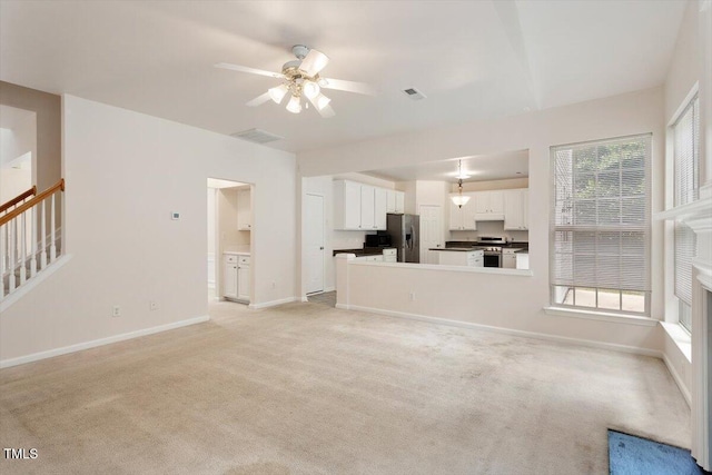 402 Halls Mill Dr, Cary, NC 27519 - unfurnished living room featuring a ceiling fan, light colored carpet, baseboards, and stairs
