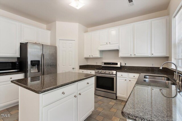 402 Halls Mill Dr, Cary, NC 27519 - kitchen featuring appliances with stainless steel finishes, a sink, white cabinetry, and a center island