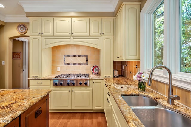 84307 Winslow, Chapel Hill, NC 27517 - kitchen featuring stainless steel gas cooktop, crown molding, light wood-style floors, decorative backsplash, and light stone counters