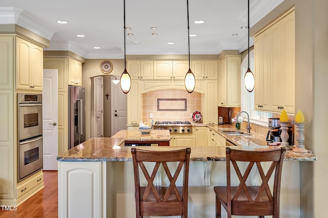 84307 Winslow, Chapel Hill, NC 27517 - kitchen with stainless steel appliances, cream cabinets, a peninsula, ornamental molding, and stone countertops