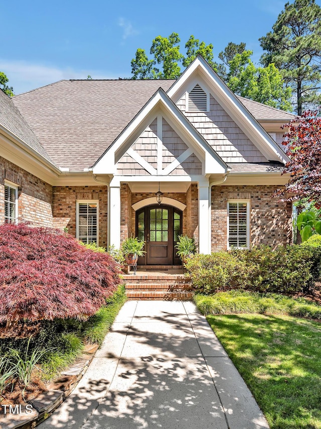 84307 Winslow, Chapel Hill, NC 27517 - property entrance with roof with shingles, brick siding, and a porch
