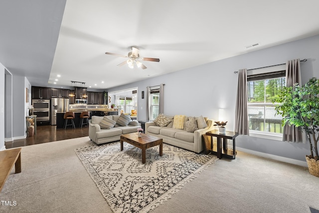 2909 Landon Pines Ct, New Hill, NC 27562 - living room featuring healthy amount of natural light, baseboards, recessed lighting, ceiling fan, and dark colored carpet