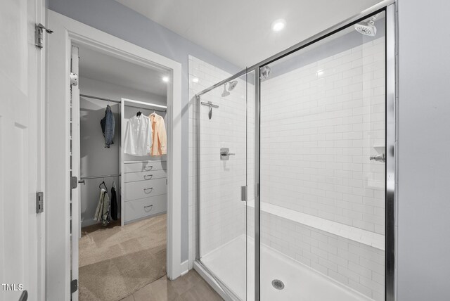 2909 Landon Pines Ct, New Hill, NC 27562 - full bathroom with a spacious closet, a shower stall, tile patterned floors, and recessed lighting
