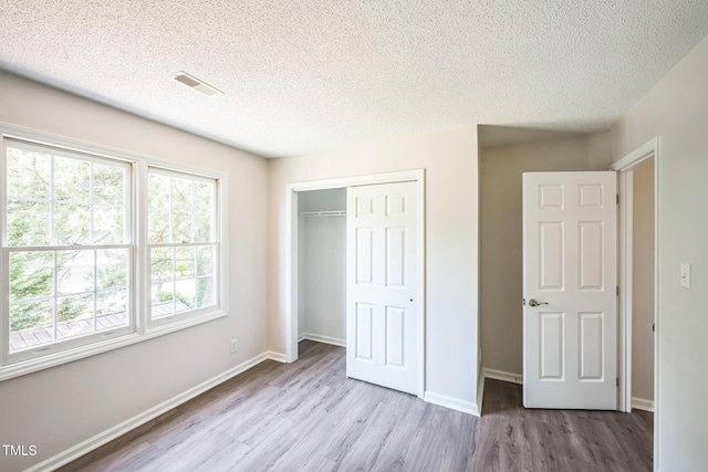 5505 Pennfine Dr, Raleigh, NC 27610 - unfurnished bedroom with wood finished floors, a textured ceiling, a closet, and baseboards
