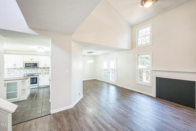 5505 Pennfine Dr, Raleigh, NC 27610 - unfurnished living room with dark wood-style flooring, high vaulted ceiling, baseboards, a fireplace, and a textured ceiling
