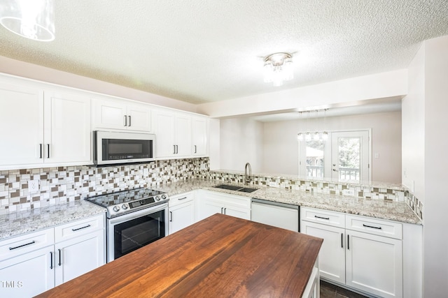 5505 Pennfine Dr, Raleigh, NC 27610 - kitchen with white appliances, wooden counters, a sink, backsplash, and white cabinets