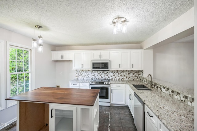 5505 Pennfine Dr, Raleigh, NC 27610 - kitchen with stainless steel appliances, a sink, butcher block counters, backsplash, and white cabinets