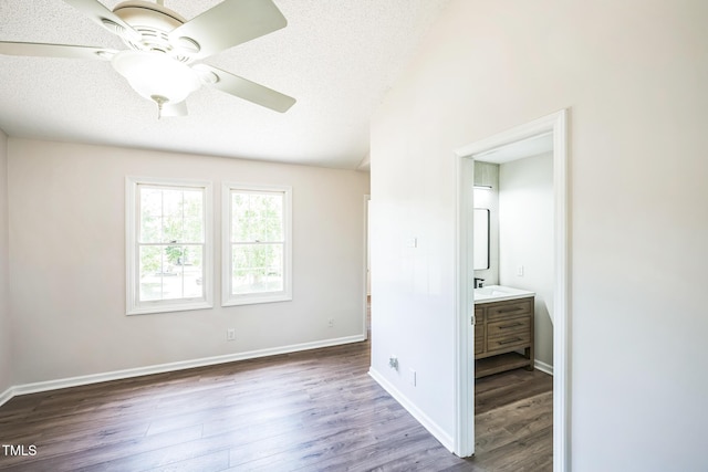 5505 Pennfine Dr, Raleigh, NC 27610 - unfurnished bedroom with wood finished floors, baseboards, ensuite bathroom, and a textured ceiling