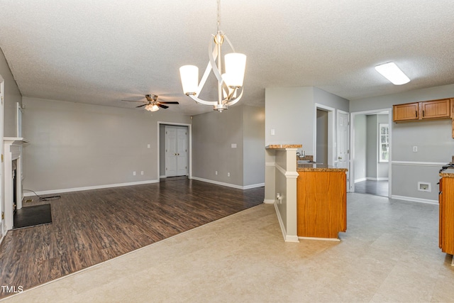 5008 Dantonville Ct, Knightdale, NC 27545 - kitchen featuring brown cabinets, a textured ceiling, a ceiling fan, baseboards, and hanging light fixtures