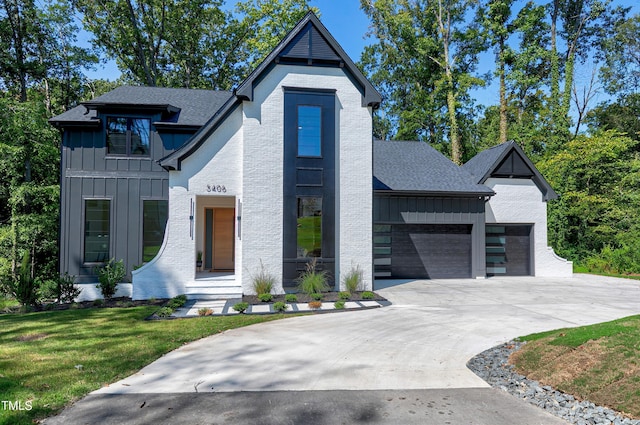 5406 Garrett Rd, Durham, NC 27707 - modern farmhouse with board and batten siding, an attached garage, driveway, a front yard, and a shingled roof