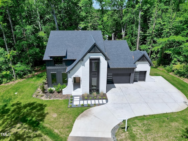 5406 Garrett Rd, Durham, NC 27707 - modern inspired farmhouse with a shingled roof, concrete driveway, board and batten siding, a front lawn, and a garage