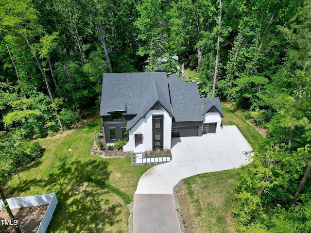 5406 Garrett Rd, Durham, NC 27707 - view of front of home with concrete driveway, a garage, a front yard, and roof with shingles