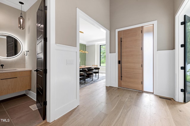 5406 Garrett Rd, Durham, NC 27707 - foyer with light wood finished floors, wainscoting, and a decorative wall