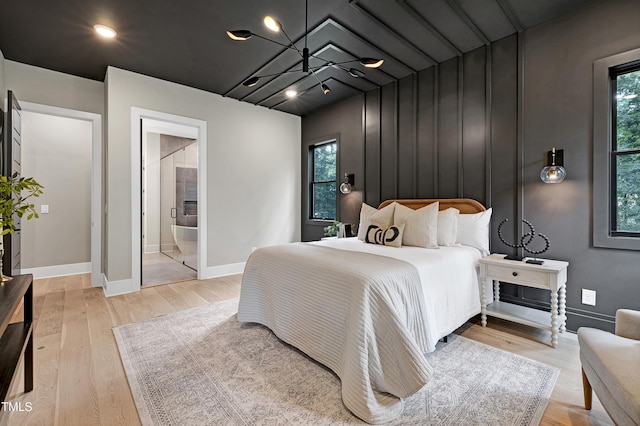 5406 Garrett Rd, Durham, NC 27707 - bedroom featuring multiple windows, light wood-style floors, a chandelier, and connected bathroom