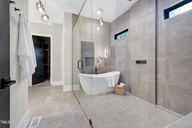 5406 Garrett Rd, Durham, NC 27707 - bathroom featuring a freestanding bath, a shower stall, and tile patterned flooring