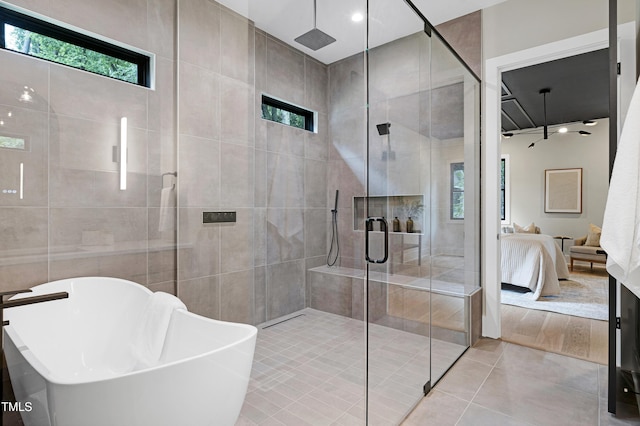5406 Garrett Rd, Durham, NC 27707 - ensuite bathroom with a soaking tub, a stall shower, tile patterned flooring, and tile walls