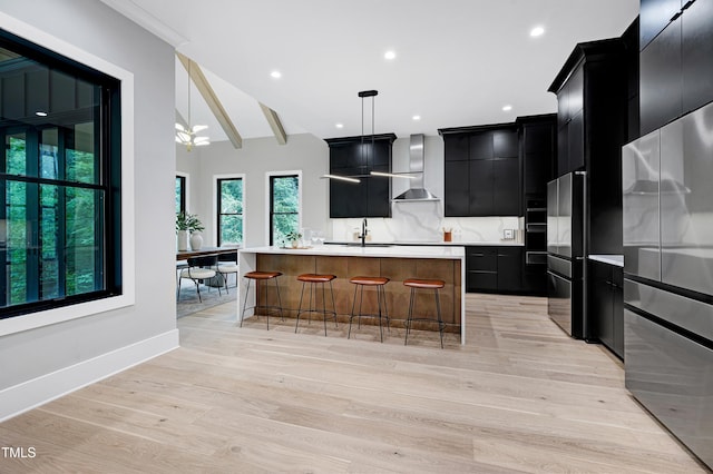 5406 Garrett Rd, Durham, NC 27707 - kitchen with dark cabinetry, light countertops, freestanding refrigerator, a center island with sink, and a breakfast bar area