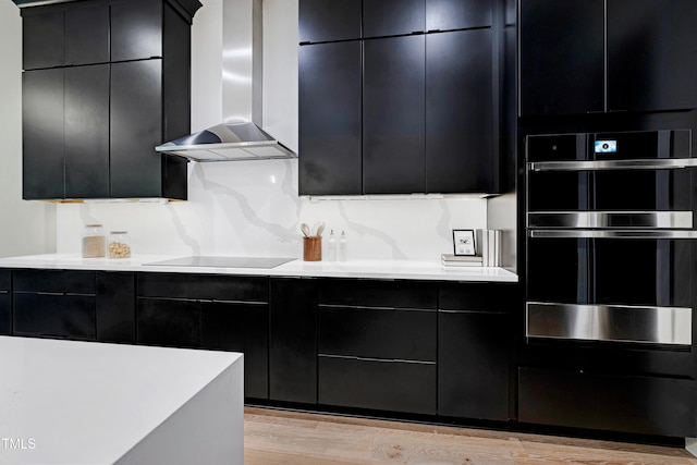 5406 Garrett Rd, Durham, NC 27707 - kitchen with wall chimney exhaust hood, double oven, dark cabinetry, and black electric stovetop