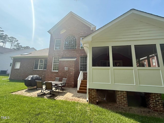 9409 Collingdale Way, Raleigh, NC 27617 - back of property featuring a sunroom, a patio area, a lawn, and brick siding