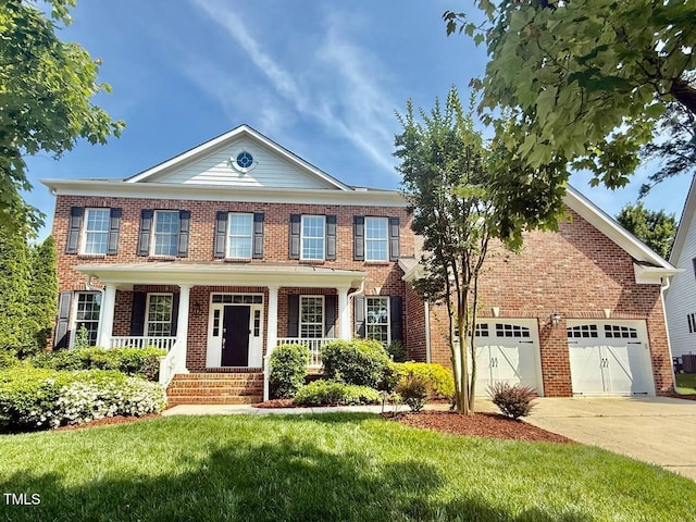 9409 Collingdale Way, Raleigh, NC 27617 - colonial inspired home featuring concrete driveway, brick siding, a porch, a front yard, and an attached garage