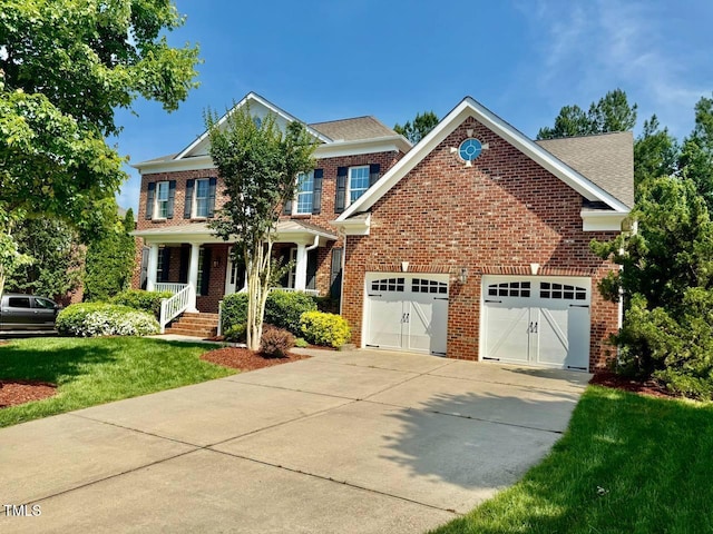 9409 Collingdale Way, Raleigh, NC 27617 - view of front of property with driveway, brick siding, a porch, a front lawn, and an attached garage