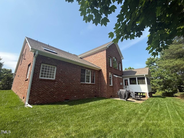 9409 Collingdale Way, Raleigh, NC 27617 - rear view of property featuring a sunroom, crawl space, a lawn, and brick siding