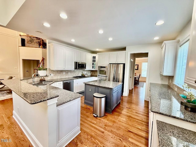 9409 Collingdale Way, Raleigh, NC 27617 - kitchen with appliances with stainless steel finishes, a sink, white cabinets, backsplash, and light wood-type flooring