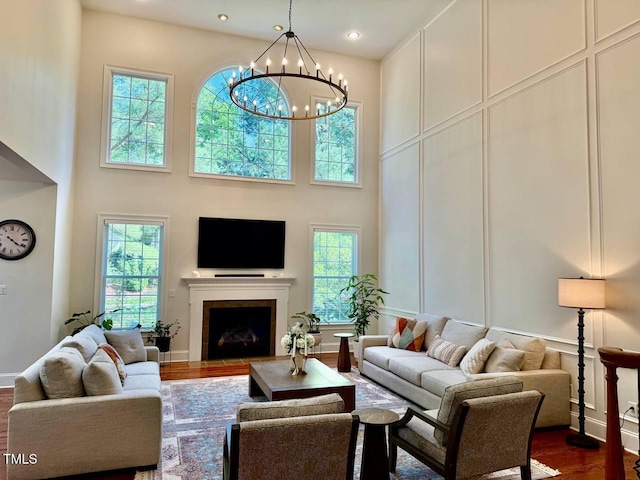 9409 Collingdale Way, Raleigh, NC 27617 - living room with plenty of natural light, a towering ceiling, dark wood-type flooring, a fireplace with flush hearth, and a chandelier