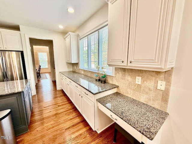 9409 Collingdale Way, Raleigh, NC 27617 - kitchen featuring light stone countertops, light wood-style floors, freestanding refrigerator, white cabinetry, and recessed lighting