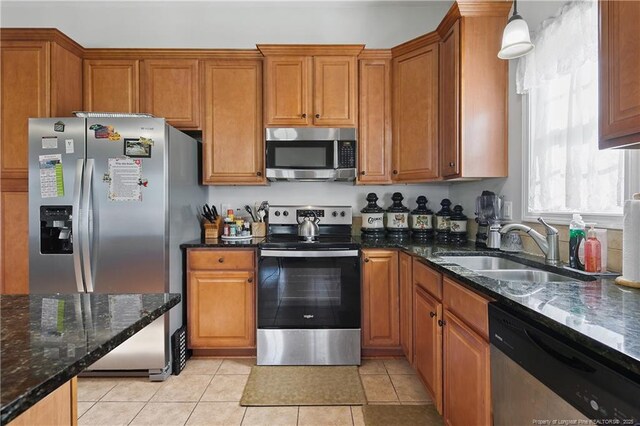 3811 Briargate Ln, Fayetteville, NC 28314 - kitchen with stainless steel appliances, a sink, brown cabinets, and dark stone countertops