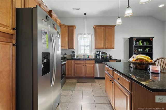3811 Briargate Ln, Fayetteville, NC 28314 - kitchen with stainless steel appliances, a sink, brown cabinetry, light tile patterned floors, and hanging light fixtures