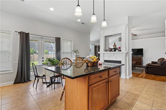 3811 Briargate Ln, Fayetteville, NC 28314 - kitchen featuring light tile patterned floors, open floor plan, baseboards, a fireplace, and a breakfast bar area