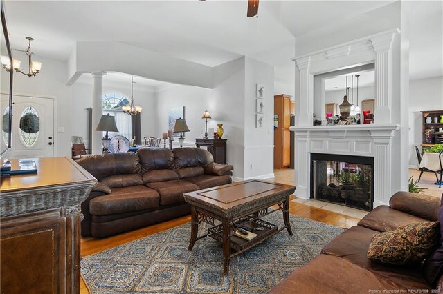 3811 Briargate Ln, Fayetteville, NC 28314 - living area featuring a chandelier, light wood finished floors, ornate columns, and a multi sided fireplace