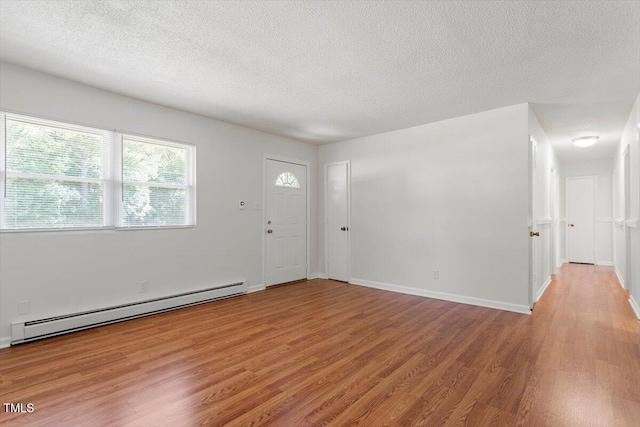 1512 Bacon St, Durham, NC 27701 - foyer entrance with a baseboard heating unit, light wood-style floors, a textured ceiling, and baseboards