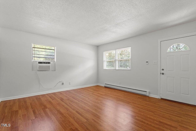 1512 Bacon St, Durham, NC 27701 - entrance foyer featuring a baseboard heating unit, wood finished floors, plenty of natural light, cooling unit, and a textured ceiling
