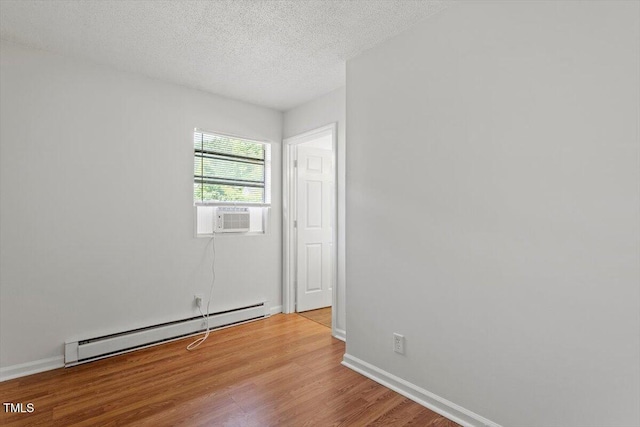 1512 Bacon St, Durham, NC 27701 - empty room with a baseboard radiator, wood finished floors, cooling unit, a textured ceiling, and baseboards