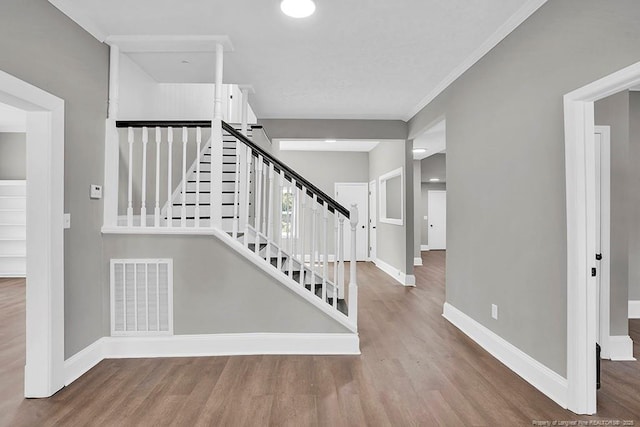 201 N College St, Red Springs, NC 28377 - staircase with baseboards, wood finished floors, and crown molding