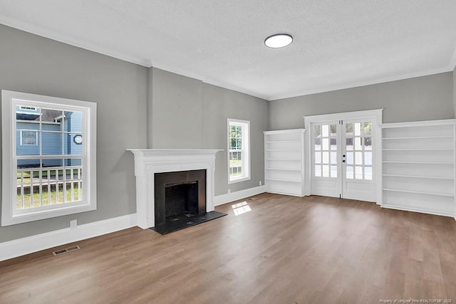 201 N College St, Red Springs, NC 28377 - unfurnished living room featuring wood finished floors, a textured ceiling, a fireplace, french doors, and crown molding