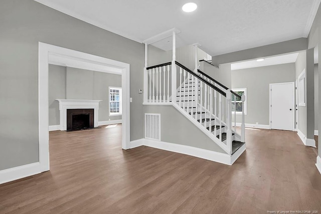 201 N College St, Red Springs, NC 28377 - stairway with wood finished floors, baseboards, and a fireplace with flush hearth