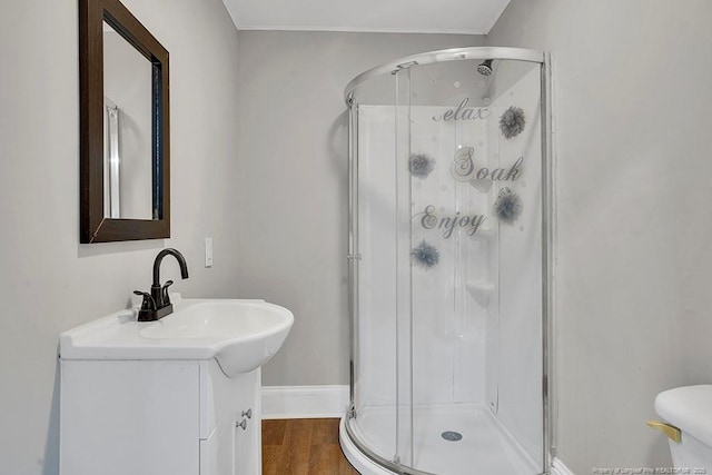 201 N College St, Red Springs, NC 28377 - full bathroom with a stall shower, vanity, wood finished floors, toilet, and baseboards