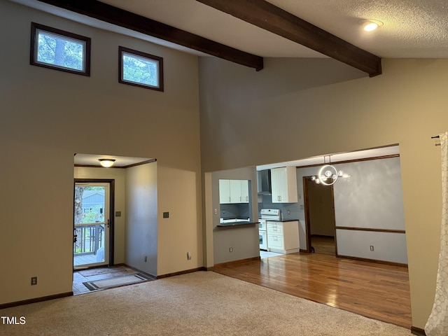 507 Holtz Ln, Cary, NC 27511 - unfurnished living room featuring carpet floors, beam ceiling, high vaulted ceiling, baseboards, and a chandelier