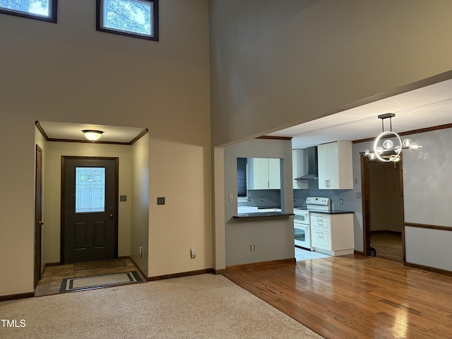 507 Holtz Ln, Cary, NC 27511 - entrance foyer with ornamental molding, a towering ceiling, light wood-style flooring, baseboards, and a chandelier