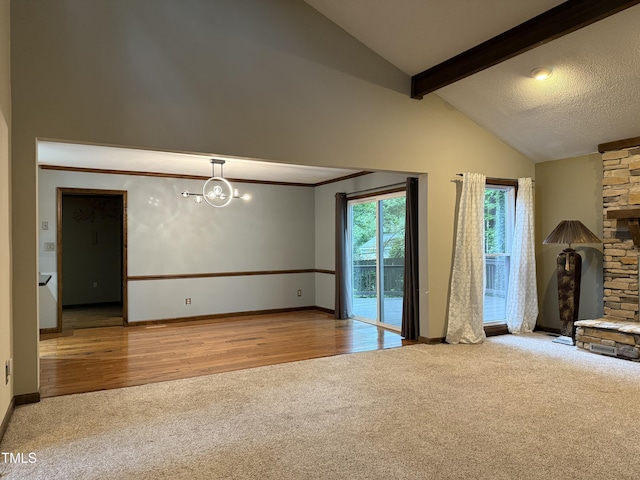 507 Holtz Ln, Cary, NC 27511 - unfurnished living room with carpet floors, high vaulted ceiling, a stone fireplace, baseboards, and a chandelier