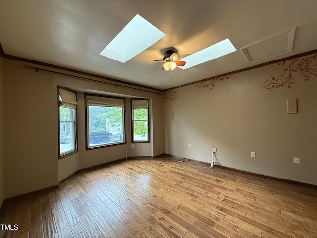 507 Holtz Ln, Cary, NC 27511 - empty room with light wood finished floors, a skylight, and baseboards