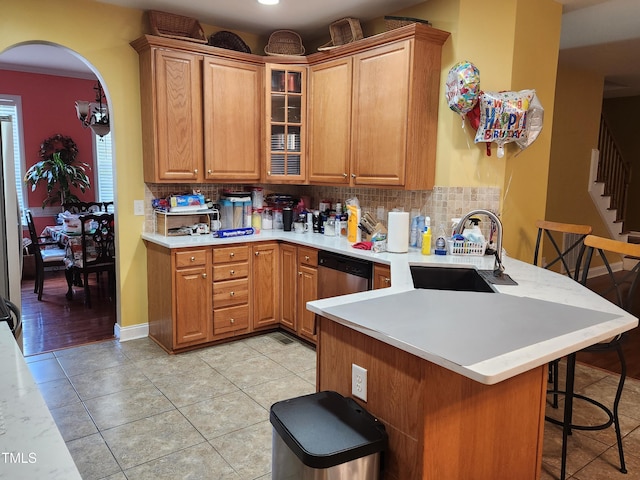 18 Clover Hil Pl, Durham, NC 27712 - kitchen with a peninsula, a breakfast bar area, tasteful backsplash, glass insert cabinets, and arched walkways