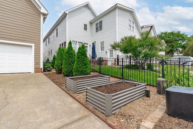 321 Commons Walk Cir, Cary, NC 27519 - view of side of home with a vegetable garden, concrete driveway, and a garage